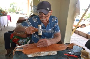 Obra. En la Expo Norte, don Mario Cecilio Duarte talla un trabajo en cuero, que realiza a pedido del cliente.