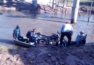 Ingenio. Los pobladores de las zonas aisladas cruzan en bote con sus motocicletas..